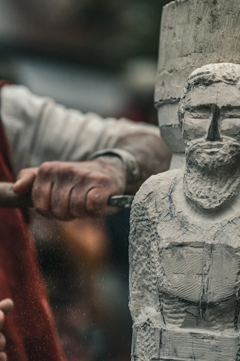 Un artisan carreleur installe des dalles de pierre naturelle grise sur une chape ciment