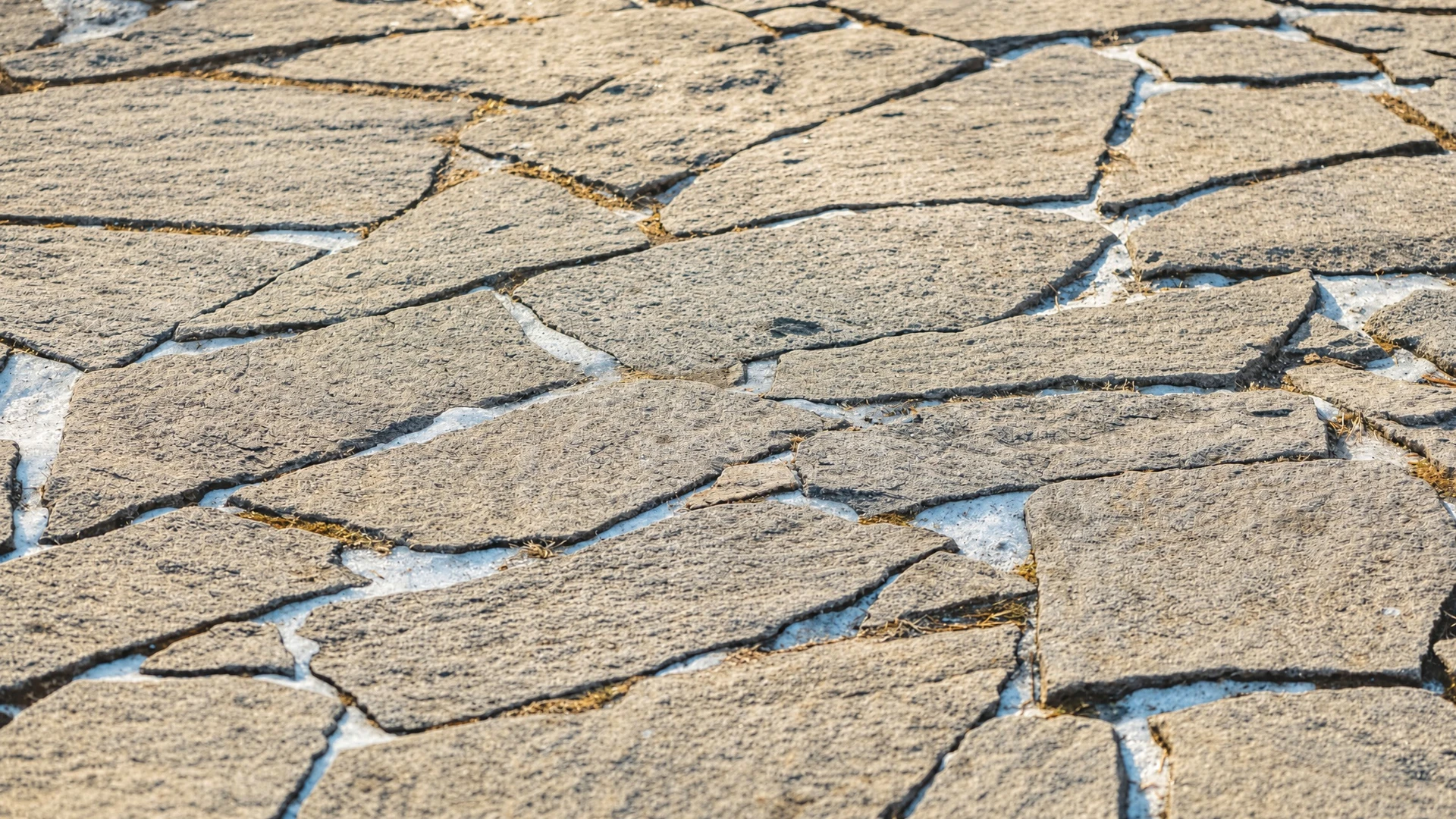 Chantier extérieur de pose de pavés en granit gris sur lit de graviers